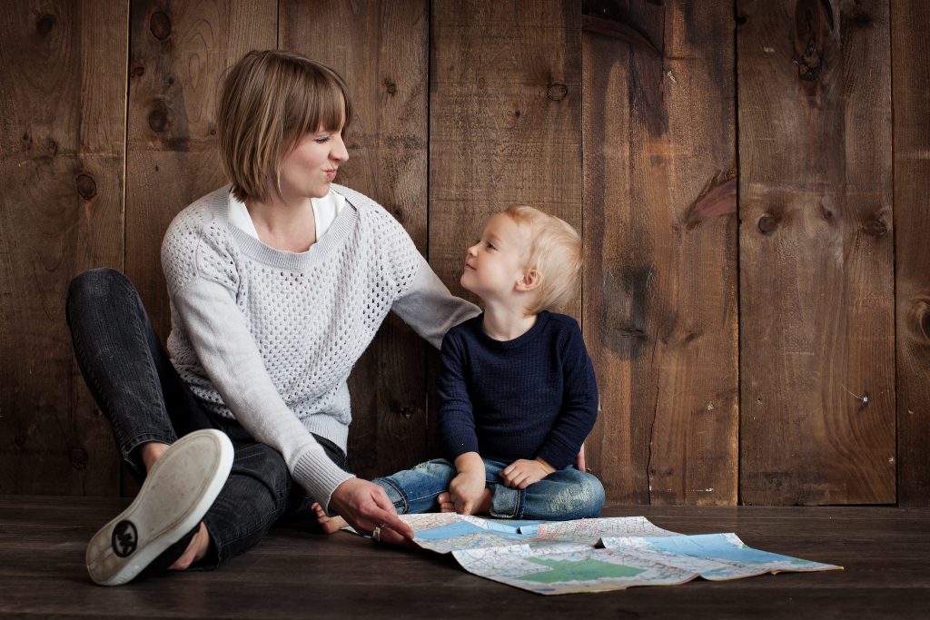 woman looking at kid with map